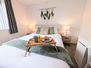 una camera da letto con un letto con un vassoio di cibo sopra di Steps from O2 Apollo, Ox road a Manchester