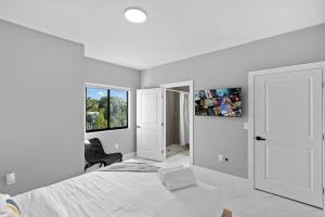 Una habitación blanca con una cama y una ventana en Amazing Townhouse w Free Parking, en Miami