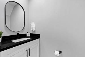 Un baño con un lavabo negro y un espejo. en Amazing Townhouse w Free Parking, en Miami