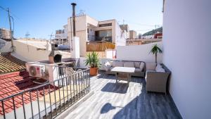 un balcon avec un canapé et des chaises sur un immeuble dans l'établissement Casa Brava, à Alicante