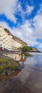 two girls walking on the beach with umbrellas at Seaview Apartment, Playa Chica, Las Gaviotas, Apartamento 311 in Santa Cruz de Tenerife