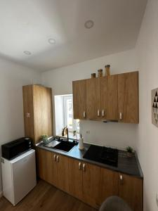 a kitchen with wooden cabinets and a sink and a refrigerator at Moin Apartment in Sibiu