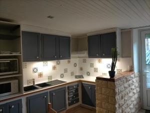 a kitchen with black cabinets and a counter top at Gîte de la Croix du Bonhomme à Champeix in Champeix