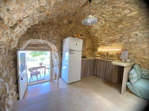 a kitchen with a refrigerator in a stone wall at Abou El Joun - Batroun in Batroûn