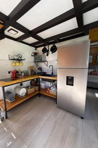 eine Küche mit einem Kühlschrank aus Edelstahl und Holzböden in der Unterkunft Casa Selva Negra in Talamanca