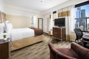 a hotel room with a bed and a tv at New Yorker by Lotte Hotels in New York +50 photos