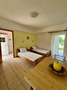 a room with two beds and a table in it at Physis Seaside Living in Preveza