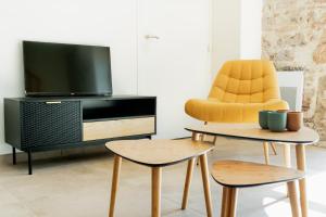 a living room with two chairs and a television at Grange La Roca Masia in Assier