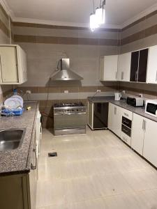 a kitchen with white cabinets and a counter top at luxury dublex with private swimming pool in Obour