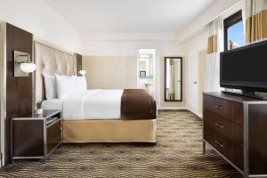 a hotel room with a bed and a flat screen tv at New Yorker by Lotte Hotels in New York