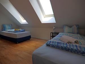 two beds in a room with two skylights at Reihenhaus am Gardersee in Garden