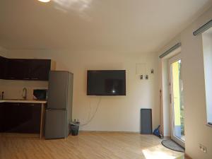 a room with a refrigerator and a tv on the wall at Reihenhaus am Gardersee in Garden