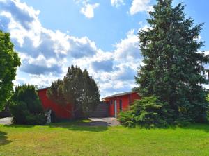 a red house with a tree in a yard at Reihenhaus am Gardersee in Garden
