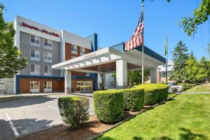 an office building with an american flag in front of it at Hampton Inn & Suites Seattle North/Lynnwood in Lynnwood