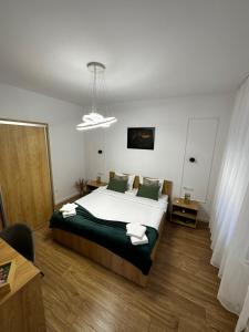 a bedroom with a large white bed with green pillows at Moin Apartment in Sibiu