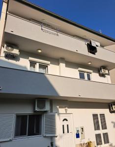 a white building with a bench on the side of it at Apartman Matea in Igrane +2 photos
