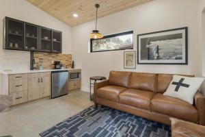 a living room with a brown leather couch in a kitchen at Cutthroat Trout Cabin Near Trails Hike and Bike in Grant