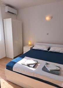 a bedroom with two beds and a white cabinet at Apartman Matea in Igrane