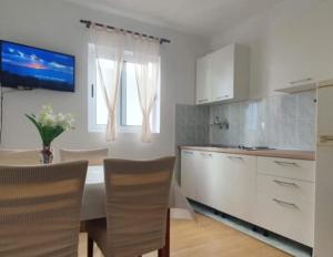 a kitchen with a table and chairs in a kitchen at Apartman Matea in Igrane