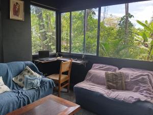 Una sala de estar con dos sofás azules y una mesa. en Suítes da Malu, en São Sebastião