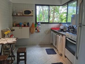 una cocina con fregadero y estufa en Suítes da Malu, en São Sebastião