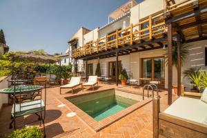 an outdoor patio with a swimming pool and a house at Casa Bombo in Granada