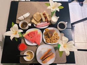 a table with plates of food and drinks and flowers at Solar Hostel Centro in Rio de Janeiro +38 photos