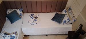 a bed with blue and white pillows on it at Apê da Terezinha in Rio de Janeiro