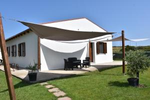 a white building with a tent in the yard at Il Vecchio Casale B&B in Sedini