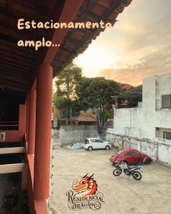 a car and a motorcycle parked in a parking lot at Residencial Dragão in Fortaleza