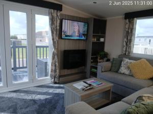 a living room with a couch and a tv at Thrillseeker - next to Fantasy Island, Ingoldmells, dog friendly in Skegness