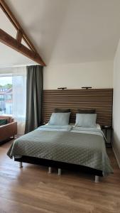 a bedroom with a large bed with a wooden headboard at Dulce Tierra - appartement in Zoutelande