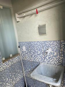 a bathroom with a tub and a tiled wall at Kitnet aconchegante in Rio das Ostras
