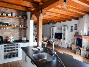 a kitchen with a sink and a brick wall at CASA RURAL EL TRASTERO DE CARMELO in Maello