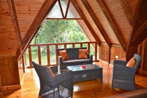 um alpendre com cadeiras, uma mesa e uma janela em Villa Pasyon em La Digue