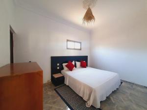 a bedroom with a white bed with red pillows at Riad Elbahi in Marrakech +33 photos