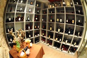a shelf filled with lots of bottles of wine at Aparthotel Meseguer in Alcañiz