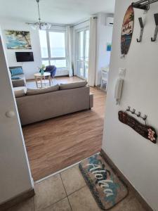 un soggiorno con un divano e un tavolo di Aloha Beach Terrace - Holiday Home a Siófok