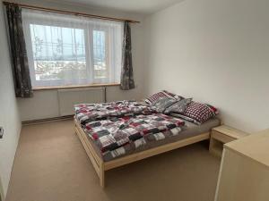 a bedroom with a bed with a quilt and a window at Apartment Světlá 