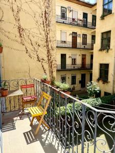 布达佩斯Churri Downtown - with Garage的阳台配有两把椅子和一张桌子,公寓大楼