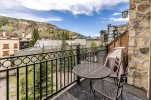 a patio with a table and chairs on a balcony at Landmark Vail - Charming Condo for 8 with Resort-style Amenities in Vail