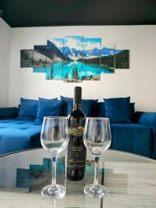 a bottle of wine and two wine glasses on a table at Globas Apartment Marasti Cluj-Napoca in Cluj-Napoca