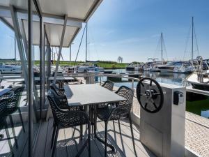 a table and chairs on the deck of a boat at Waterlodge in Kamperland by Veerse Meer in Kamperland