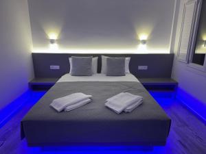 a bedroom with a bed with two towels on it at WHITE & BLUE Kamari in Kamari