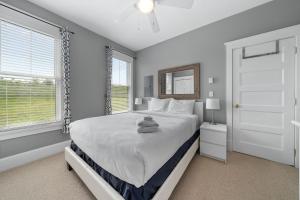a white bedroom with a bed and a window at The Rushes - 47 Butternut in Cherry Valley