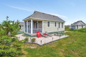 a house with a deck with two chairs and a table at The Rushes - 47 Butternut in Cherry Valley