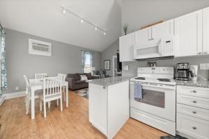 a kitchen with white appliances and a living room at The Rushes - 47 Butternut in Cherry Valley