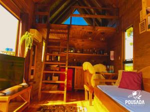 a wooden cabin with a loft bed and a ladder at Chalé na Pousada Eco das Aves próximo a vinícola Thera in Bom Retiro