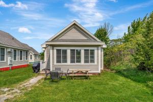 a house with a table and chairs in the yard at The Cattail - 26 Meadowview in Cherry Valley