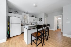 a kitchen with white appliances and a counter with stools at The Cattail - 26 Meadowview in Cherry Valley
